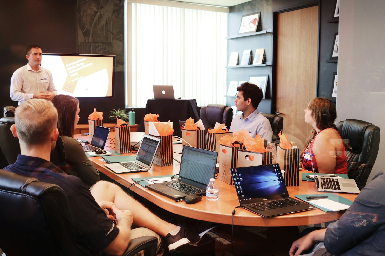 Professionals meeting around a boardroom table with laptops